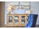 Stylish console table with glass doors, adorned with decor and set under landscape paintings at 1238 Exchange Pl, Durham, NC 27713