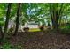 Shaded backyard offers a tranquil retreat with mature trees and natural surroundings; perfect for relaxing outdoors at 1241 Dalgarven Dr, Apex, NC 27502
