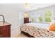 Bright bedroom with a ceiling fan, large windows and a floral comforter and wood furnishings at 1241 Dalgarven Dr, Apex, NC 27502
