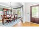 Bright dining room with a wooden table, cushioned chairs, chandelier, and a bay window with backyard views at 1241 Dalgarven Dr, Apex, NC 27502