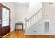 Inviting foyer with wood floors, half wall trim, staircase, and a wood door with decorative leaded glass at 1241 Dalgarven Dr, Apex, NC 27502