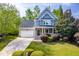 Charming two-story home featuring a well-manicured lawn, mature trees, and a welcoming front porch at 1241 Dalgarven Dr, Apex, NC 27502