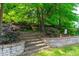 Stone steps lead through lush landscaping to a private backyard space, creating a serene outdoor environment at 1241 Dalgarven Dr, Apex, NC 27502