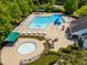 Aerial view featuring a sparkling swimming pool, wading pool, and surrounding amenities within a gated community at 1241 Dalgarven Dr, Apex, NC 27502