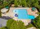 Aerial view of pool with lap lanes, a slide, and seating areas, all surrounded by lush landscaping and mature trees at 1241 Dalgarven Dr, Apex, NC 27502