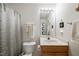 Bathroom with oak cabinets, a large mirror, and a combined tub and shower at 126 Star Thistle Ln, Cary, NC 27513