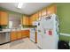 Functional kitchen with oak cabinetry, white appliances, and a convenient pass-through to the living area at 126 Star Thistle Ln, Cary, NC 27513