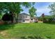 Large backyard featuring a spacious lawn, deck, mature trees, and a garden at 1321 Bloomingdale Dr, Cary, NC 27511
