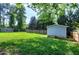 Well-maintained and expansive backyard with mature trees, a shed, and a fence at 1321 Bloomingdale Dr, Cary, NC 27511