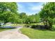 Landscaped front yard featuring lush trees and a well-maintained lawn and large driveway at 1321 Bloomingdale Dr, Cary, NC 27511