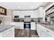 Modern kitchen showcasing stainless steel appliances, granite countertops, and stylish white cabinetry at 1321 Bloomingdale Dr, Cary, NC 27511