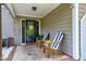 Inviting front porch with striped chairs, decorative string lights, and a view of the home's entrance at 1321 Bloomingdale Dr, Cary, NC 27511