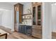 Bar area with wooden cabinets, shelves, white subway tile backsplash, and a wine cooler at 1400 Hedgelawn, Raleigh, NC 27615