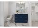 Bathroom with navy vanity, marble floors, and bright lighting at 1400 Hedgelawn, Raleigh, NC 27615