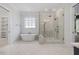 Bright bathroom with a soaking tub, glass shower, and neutral tile flooring at 1400 Hedgelawn, Raleigh, NC 27615