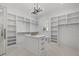 Large walk-in closet with an island, custom shelving, and stylish lighting fixture at 1400 Hedgelawn, Raleigh, NC 27615