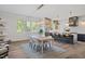 Dining area featuring modern lighting fixtures, adjacent to a kitchen island with bar seating at 1400 Hedgelawn, Raleigh, NC 27615