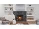 Close-up of a stylish fireplace with a dark marble surround and decorative shelving, enhancing the room's appeal at 1400 Hedgelawn, Raleigh, NC 27615