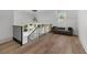Foyer area with hardwood floors, decorative railing, and a sitting area with a gray sofa at 1400 Hedgelawn, Raleigh, NC 27615