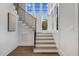 Staircase with hardwood steps and floors, metal handrail, and large windows to bring in natural light at 1400 Hedgelawn, Raleigh, NC 27615