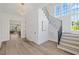 Hallway with wood floors, white walls, stairs with metal handrail and large windows at 1400 Hedgelawn, Raleigh, NC 27615