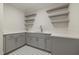 Laundry room with grey cabinets, white countertop, and open shelving at 1400 Hedgelawn, Raleigh, NC 27615