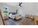 Bright main bedroom featuring large windows, a ceiling fan, and a cozy seating area at 1400 Hedgelawn, Raleigh, NC 27615