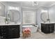 A luxurious bathroom is showcased, featuring double vanities, a soaking tub, and a decorative light fixture at 14013 Wallberman Dr, Wake Forest, NC 27587
