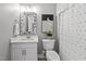 Well-lit bathroom with a white vanity, toilet, neutral color scheme and decorative mirror and artwork at 14013 Wallberman Dr, Wake Forest, NC 27587