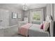 A stylish bedroom featuring a bed with decorative pillows, a dresser and a modern light fixture at 14013 Wallberman Dr, Wake Forest, NC 27587