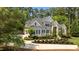 Two-story home featuring a manicured lawn, mature trees, a stone facade, and a paved driveway at 14013 Wallberman Dr, Wake Forest, NC 27587