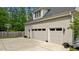 Exterior view of the garage featuring three doors, a concrete driveway, and basketball hoop at 14013 Wallberman Dr, Wake Forest, NC 27587