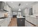 Bright, modern kitchen with white cabinets, gray island, stainless appliances and hardwood flooring at 14013 Wallberman Dr, Wake Forest, NC 27587