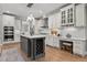 Spacious kitchen with white cabinets, quartz countertops, a large island with wine rack, and stainless steel appliances at 14013 Wallberman Dr, Wake Forest, NC 27587