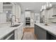 Open kitchen with stainless steel appliances, quartz countertops, hardwood floors, and lots of white cabinets at 14013 Wallberman Dr, Wake Forest, NC 27587