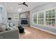 Cozy living room with vaulted ceilings, stone fireplace, skylight, plantation shutters, and hardwood flooring at 14013 Wallberman Dr, Wake Forest, NC 27587