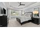 Main bedroom featuring tray ceilings, neutral color palette, and windows with a view of the pool area at 14013 Wallberman Dr, Wake Forest, NC 27587