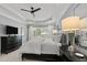 Bright main bedroom featuring tray ceilings, a ceiling fan and an oversized window with a view to the home's exterior at 14013 Wallberman Dr, Wake Forest, NC 27587