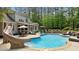 Backyard view of a pool with a slide, patio dining, and lush landscaping at 14013 Wallberman Dr, Wake Forest, NC 27587