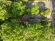Overhead view of the property featuring a well-kept backyard with a new fence, lush trees, and a glimpse of nearby streets at 1402 W Lakewood Ave, Durham, NC 27707