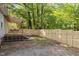 View of the backyard with a wooden deck covered by a pergola, newly installed wooden fence, and partial view of the house at 1402 W Lakewood Ave, Durham, NC 27707