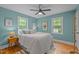 This bedroom has two windows, a ceiling fan, and hardwood flooring at 1402 W Lakewood Ave, Durham, NC 27707