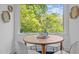 Dining area with a round wooden table and natural light coming through the window at 1402 W Lakewood Ave, Durham, NC 27707