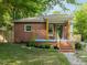 Charming brick home with a cozy front porch and beautifully landscaped front yard at 1402 W Lakewood Ave, Durham, NC 27707