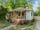 Charming brick home with craftsman-style porch, features modern cable railing, and is surrounded by lush landscaping at 1402 W Lakewood Ave, Durham, NC 27707