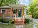Charming brick home featuring an inviting front porch, lovely landscaping and a blue front door at 1402 W Lakewood Ave, Durham, NC 27707