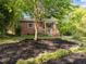 Charming brick home with wood and cable railing on the porch surrounded by meticulously laid black mulch and thriving plants at 1402 W Lakewood Ave, Durham, NC 27707