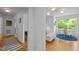 Bright hallway leads to an eat-in kitchen with hardwood floors and views of the outdoors at 1402 W Lakewood Ave, Durham, NC 27707