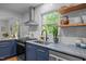Updated kitchen features navy cabinets, stainless appliances, floating shelves and bright, natural light at 1402 W Lakewood Ave, Durham, NC 27707