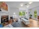 Bright living room featuring a fireplace, hardwood floors, and a view of the outdoors at 1402 W Lakewood Ave, Durham, NC 27707